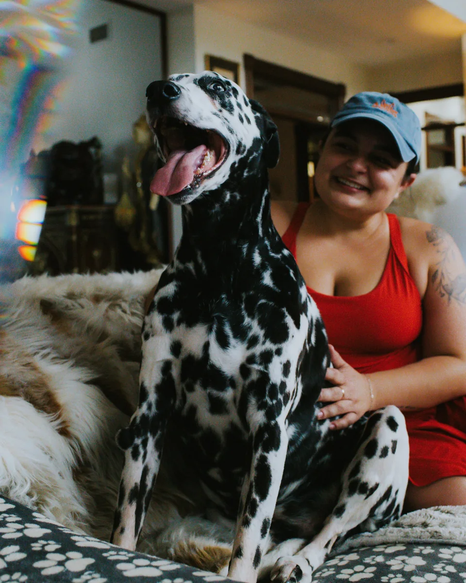 Alex Miller smiling beside a happy Dalmatian.